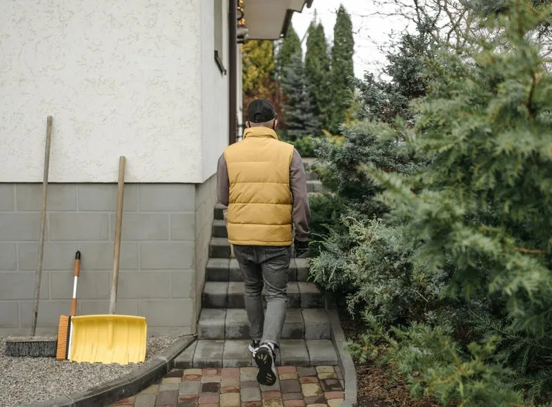 Worker maintaining a landscaped property in winter