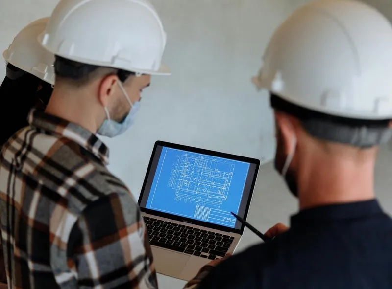 Contractors reviewing project plans on a laptop